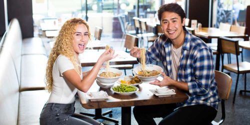 Pictures at RAKKAN Ramen Redondo Beach, 2 customers are eating ramen and smiling.